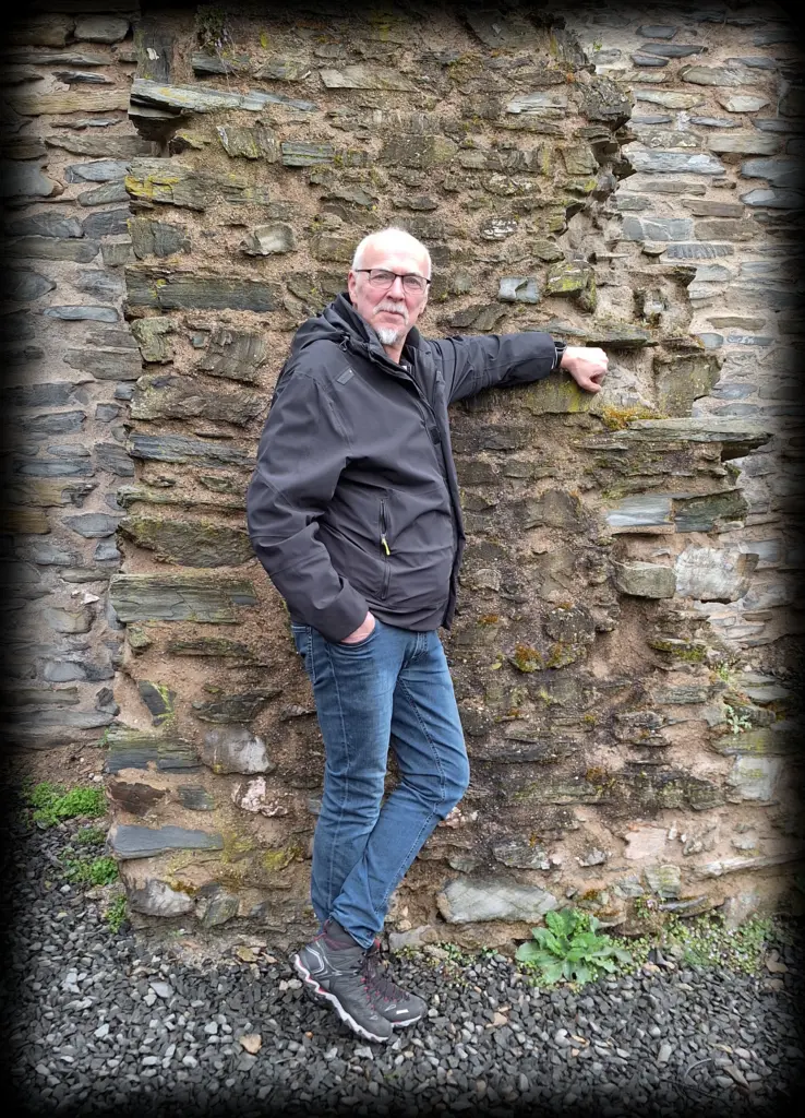 Tom Wahlfeld lehnt an einer alten Mauer von Burg Landshut bei Bernkastel-Kues – Autorenreise 2025