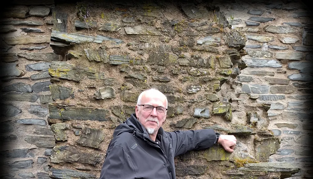 Tom Wahlfeld lehnt an einer alten Mauer von Burg Landshut bei Bernkastel-Kues – Autorenreise 2025 Ausschnitt