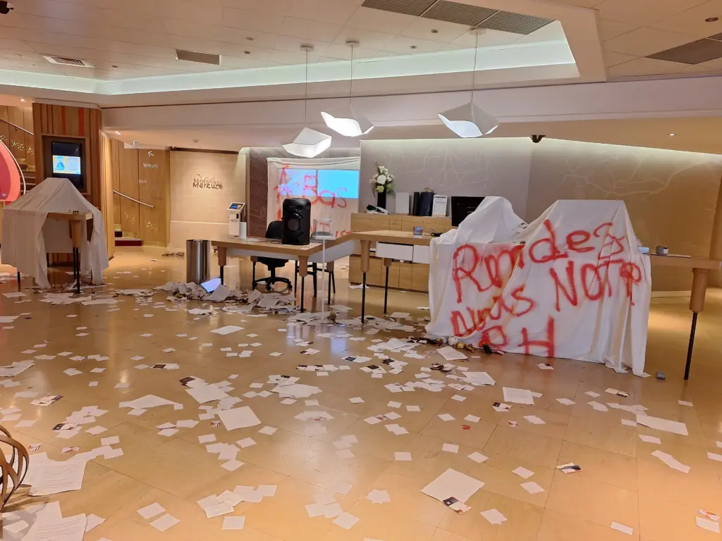 Empfangsbereich eines Pariser Hotels während eines Streiks – Papier auf dem Boden, Möbel abgedeckt, Graffiti mit Protestbotschaft